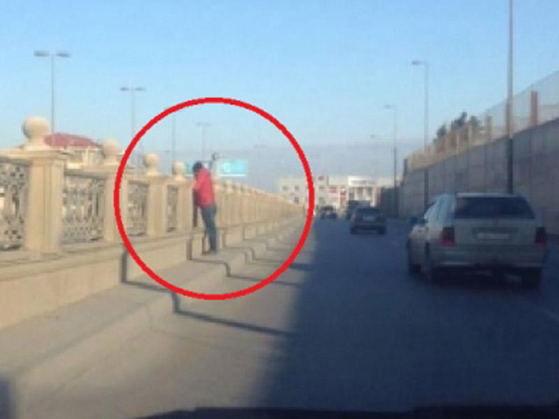 Bakıda körpüdə dayanan bu şəxs sürücüləri güdüb yol polisinə xəbər verir - FOTO
